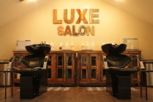 Salon chair with "Luxe Salon" logo in background